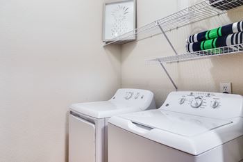 A white washing machine and dryer in a laundry room.